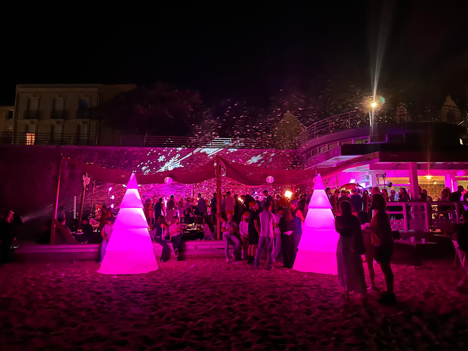 Ambiance de soirée en extérieur avec éclairages roses et décors lumineux