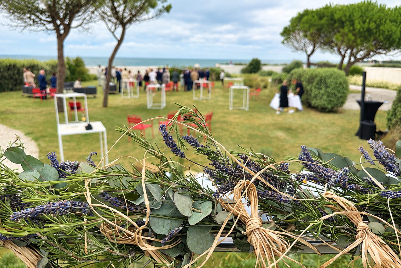 Cocktail de mariage dans un jardin face à l’océan, avec décoration végétale