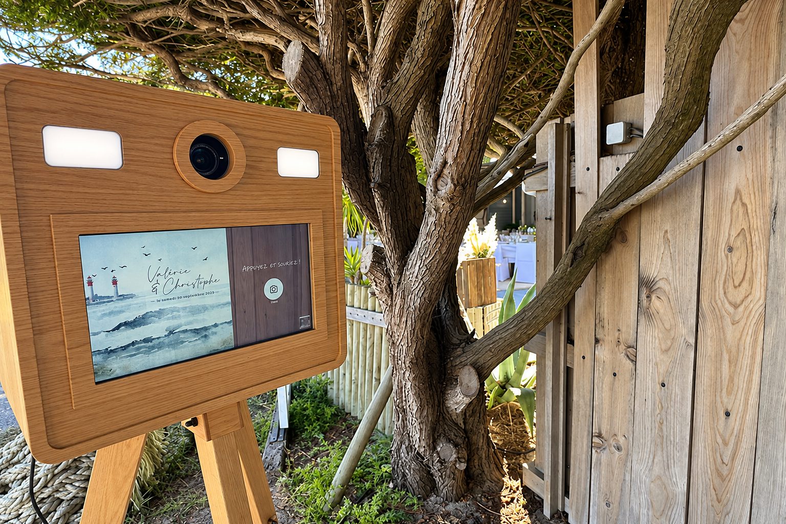 Photobooth en bois installé en extérieur à l’ombre des arbres