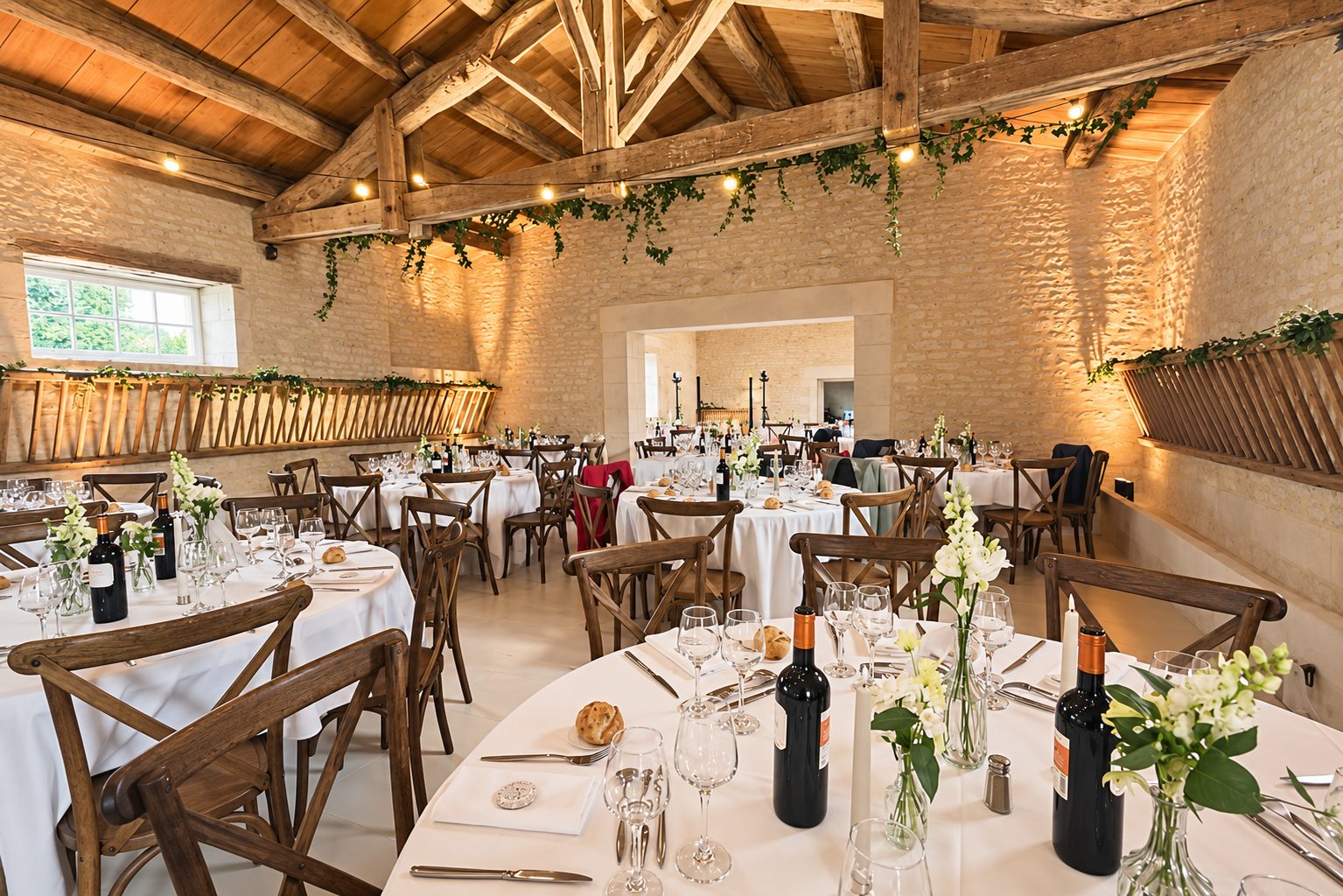 Tables fleuries sous une charpente en bois et une lumière ambrée
