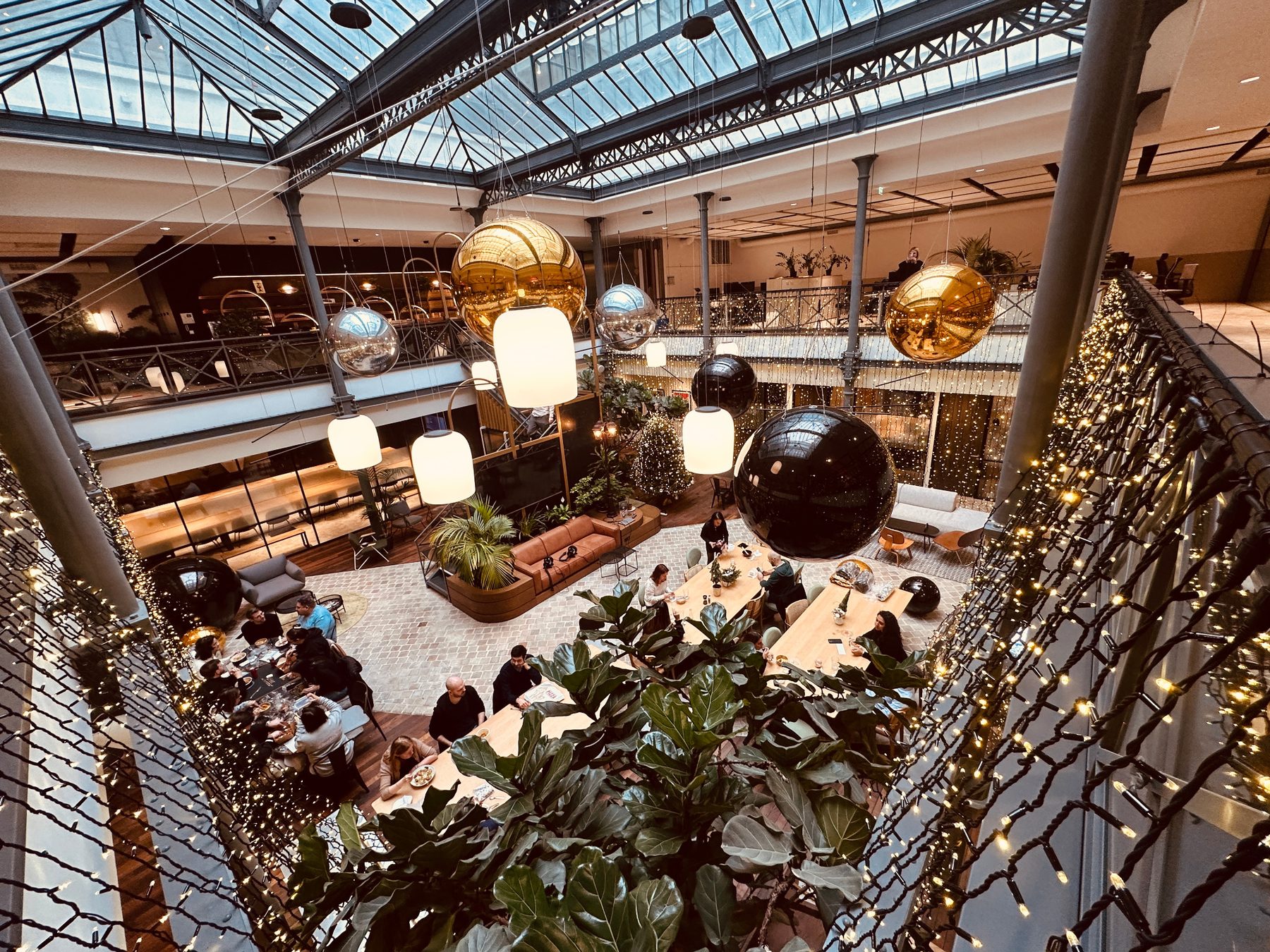 Atrium décoré de grandes sphères miroir et de guirlandes lumineuses