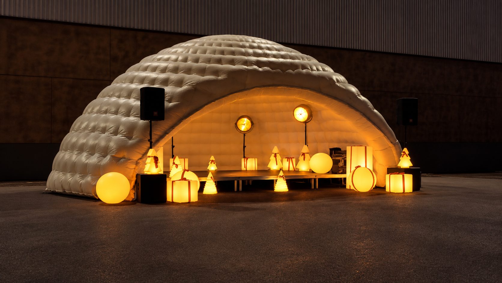Igloo gonflable et mobilier lumineux ambré dans un espace événementiel
